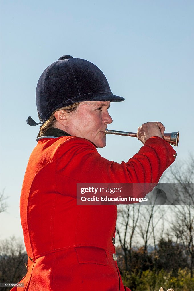 Huntsman blowing horn to call fox hounds at the Iroquois Hunt in Kentucky