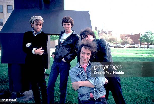 Portrait of the band REM posing outdoors next to a sculpture at Park West, Chicago, Illinois, May 26, 1983.