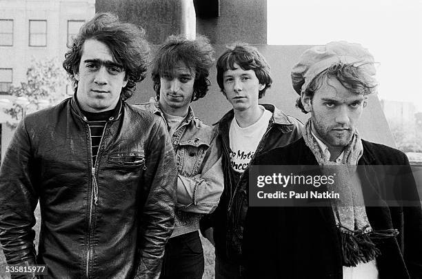 Portrait of the band REM posing outdoors next to a sculpture at Park West, Chicago, Illinois, May 26, 1983.