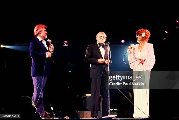 From left, American musician Kenny Rogers, comedian George Burns, and singer Dottie West perform at the Rosemont Horizon , Rosemont, Illinois, May...