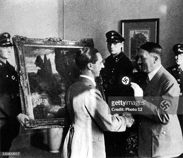 World War II, Hitler and Joseph Goebbels looking at works of art stolen from the Italians.