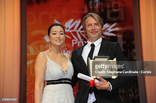 Gong Li poses with Mads Mikkelsen who received the Best Actor award for his role in 'The Hunt' at the Closing Ceremony, during the 65th Annual Cannes...
