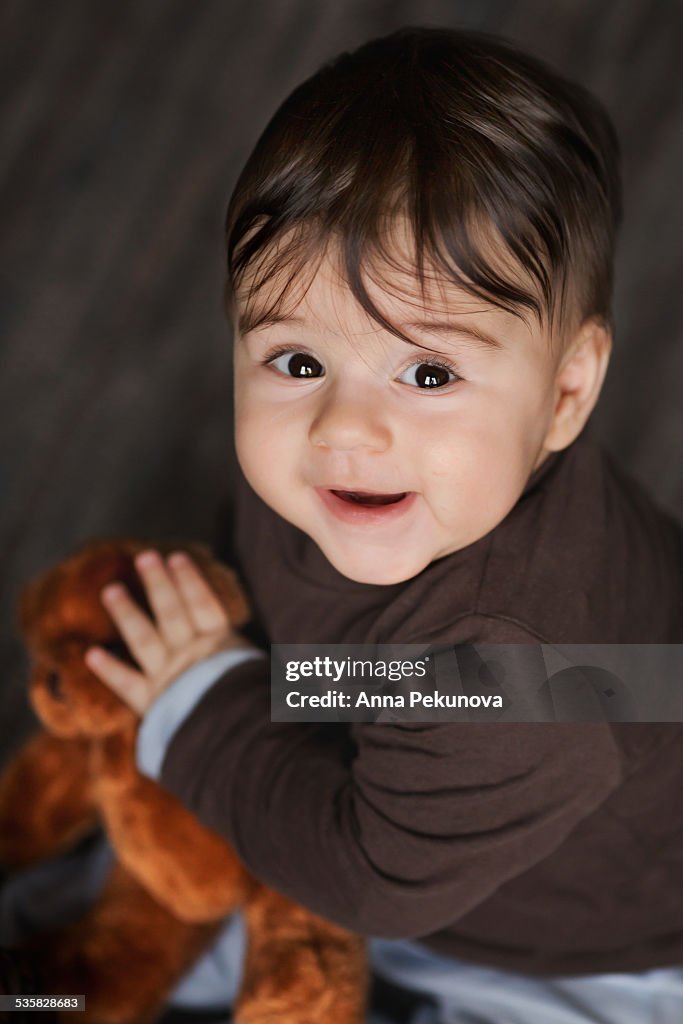 Baby boy holding teddy bear