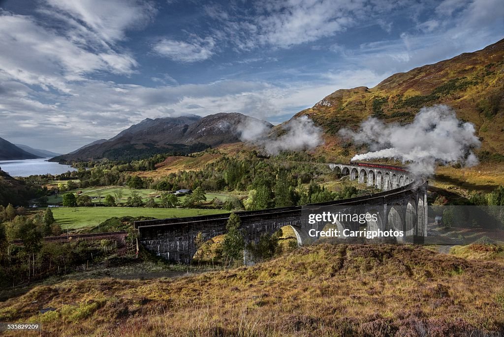 UK, Scotland, Elevated view of Jacobite Express crossing Glenfinnan Viaduct