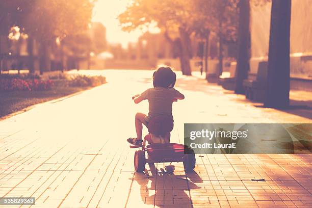 little girl(2-3) on tricycle in park - tricycle stock pictures, royalty-free photos & images