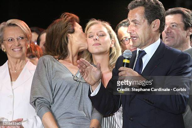 Cecilia Sarkozy kisses her daughter as her husband, Union for a Popular Movement party leader and president elect Nicolas Sarkozy addresses his...