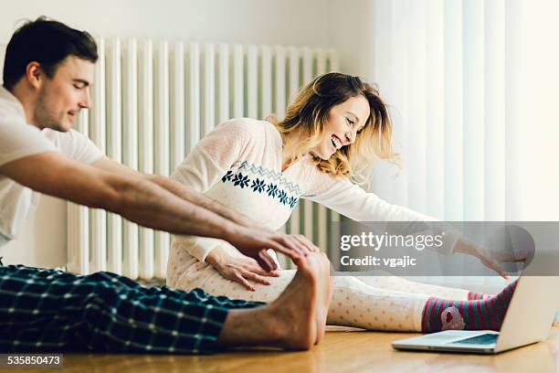 couple exercise in a living room with laptop. - babygro stock pictures, royalty-free photos & images