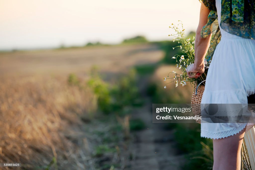Nutzpflanze der Frau mit dem Fahrrad durch Feld von Weizen