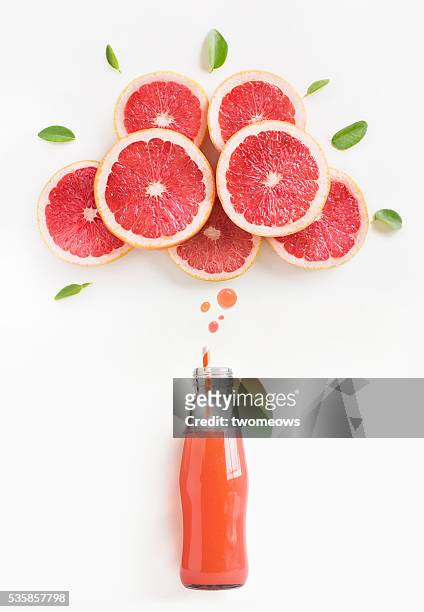 grapefruit juice in bottle with thinking bubbles formed by slice of grapefruit. - pink grapefruit stock pictures, royalty-free photos & images