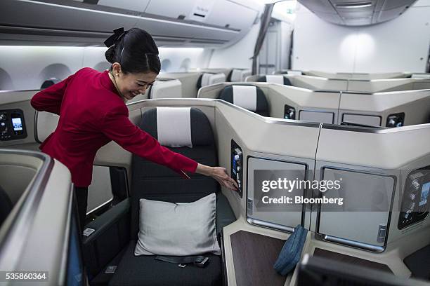 Flight attendant adjusts a business-class seat onboard an Airbus Group SE A350-900 aircraft operated by Cathay Pacific Airways Ltd. During a media...