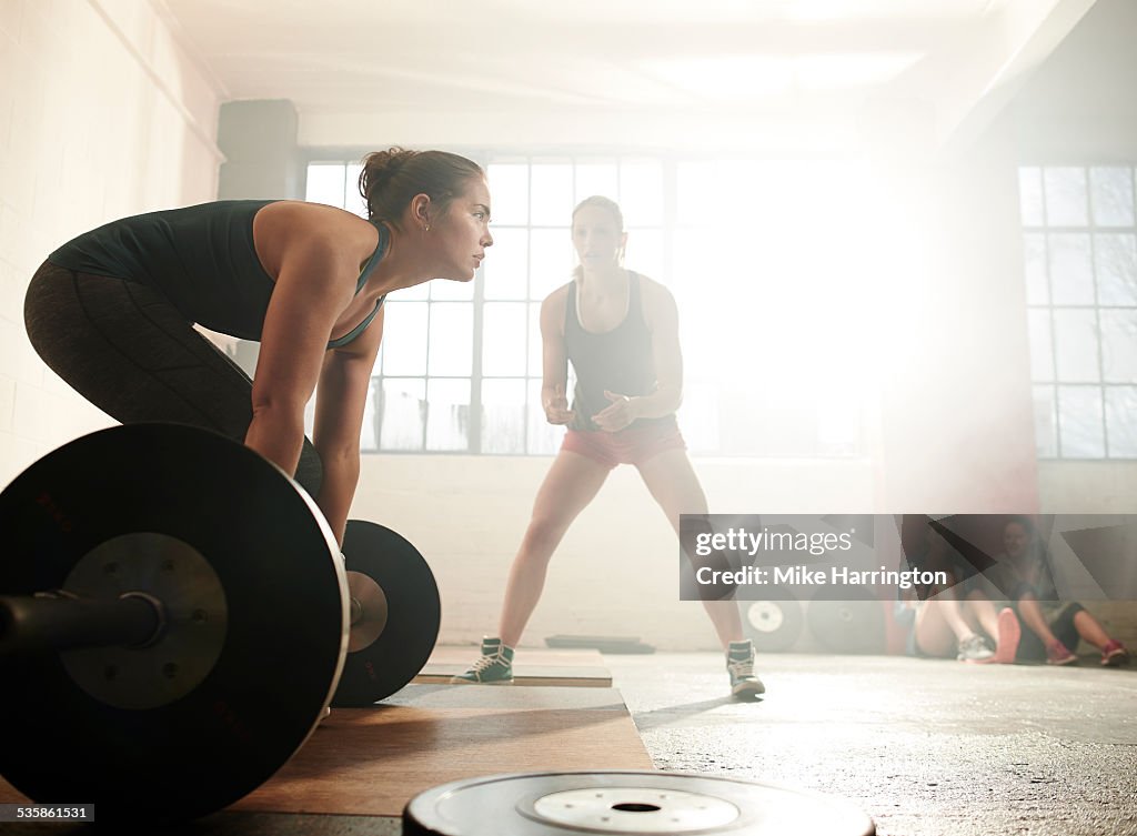 Female in warehouse gym, preparing for deadlift