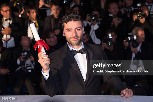 Actor Oscar Isaac poses on behalf of directors Joel and Ethan Coen after they were awarded with the Grand Prix for the film 'Inside Llewyn Davis' at...