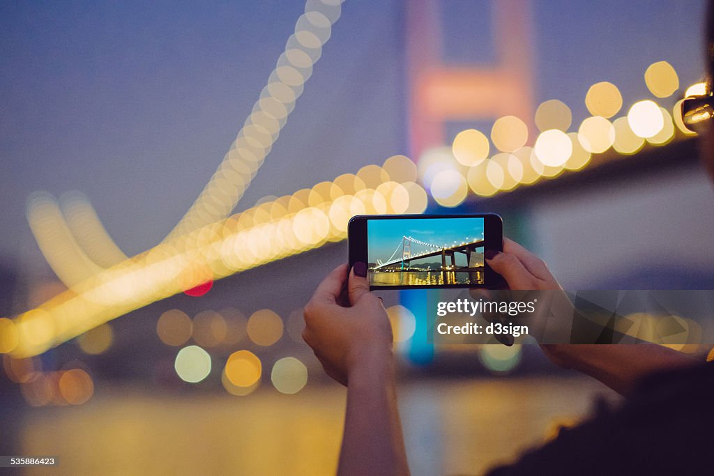 Hands photographing spectacular view by smartphone