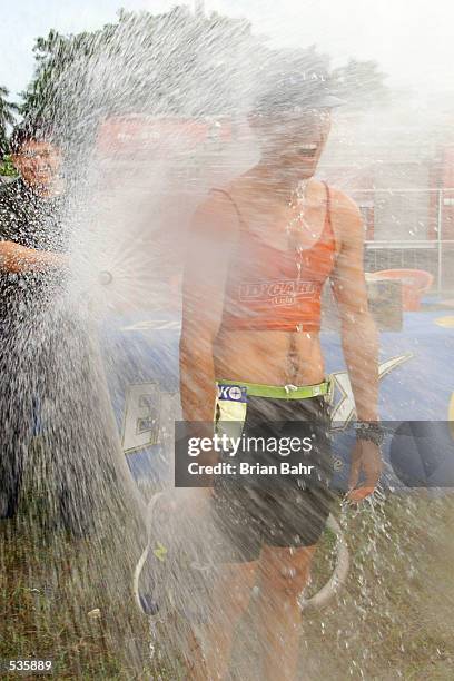 Uzziel Valderrabano of Mexico cools off in the spray of a fire hose after finishing the ITU Triathlon World Cup in Cancun, Mexico, with Hurricane...