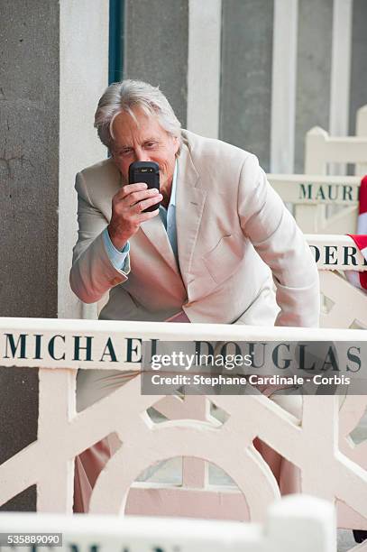 Michael Douglas poses next to the beach closet dedicated to him during a photocall on the Promenade des Planches for the movie 'Behind the...