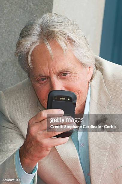 Michael Douglas poses next to the beach closet dedicated to him during a photocall on the Promenade des Planches for the movie 'Behind the...