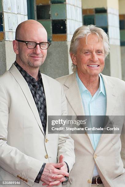 Michael Douglas and Steven Soderbergh pose next to the beach closet dedicated to them during a photocall on the Promenade des Planches for the movie...