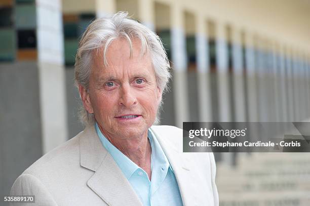 Michael Douglas poses next to the beach closet dedicated to him during a photocall on the Promenade des Planches for the movie 'Behind the...