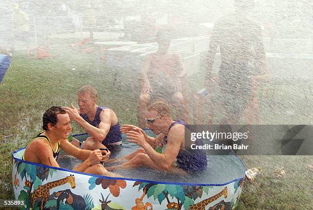 Points leader Chris Hill of Australia cools off in the kiddie pool with Joe Umphenour of the USA and Mark Fretta of the USA under the spray of a fire...