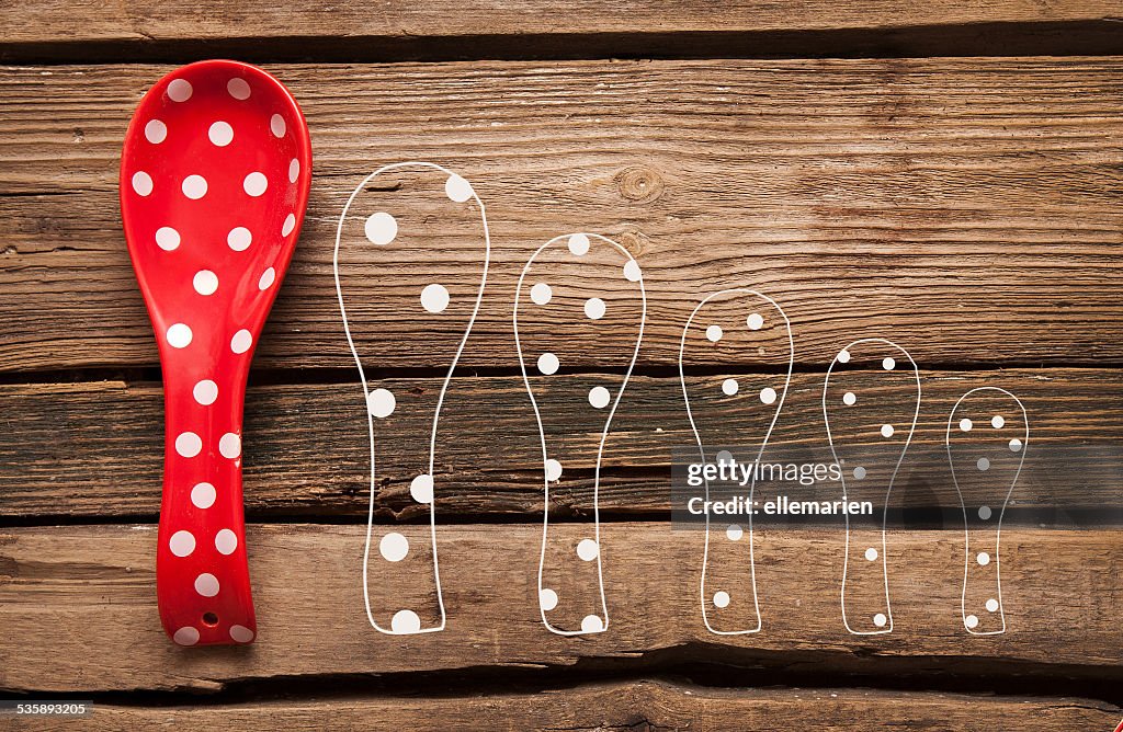 Kochen red Löffel mit polka dots auf hölzernen Hintergrund