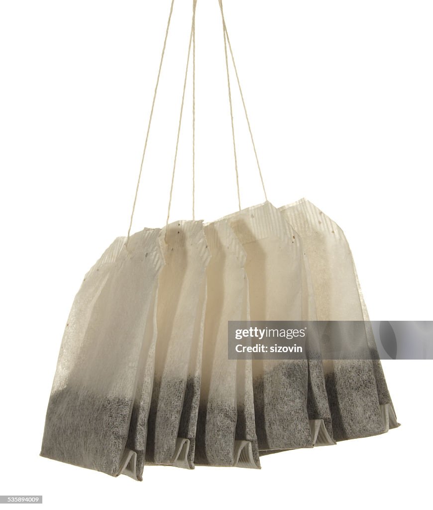 Five tea bags close-up isolated on white background