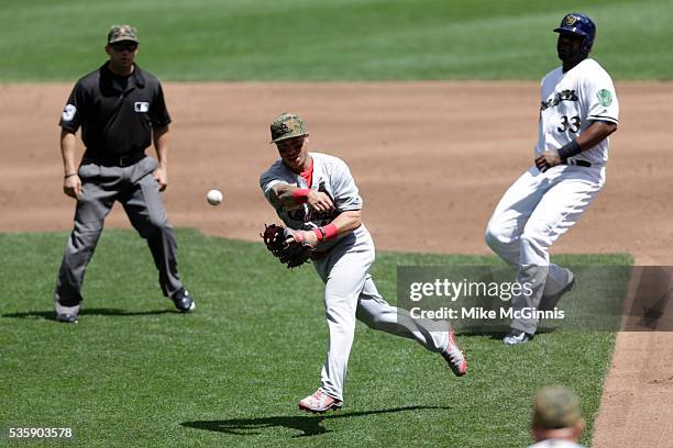 Kolten Wong of the St. Louis Cardinals tags out Chris Carter of the Milwaukee Brewers and makes the throw to first base for a double play during the...