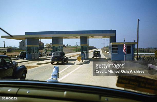 View of a truck driver, driving a Mack Truck through a toll for Cooper Jarrett Motor Freight Lines in Illinois.