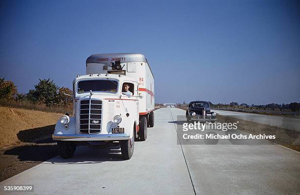 View of a truck driver, driving a Mack Truck down the interstate for Cooper Jarrett Motor Freight Lines in Illinois.