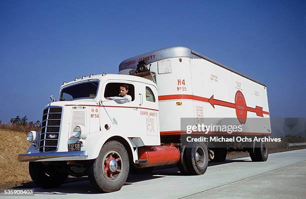 View of a truck driver, driving a Mack Truck down the interstate for Cooper Jarrett Motor Freight Lines in Illinois.