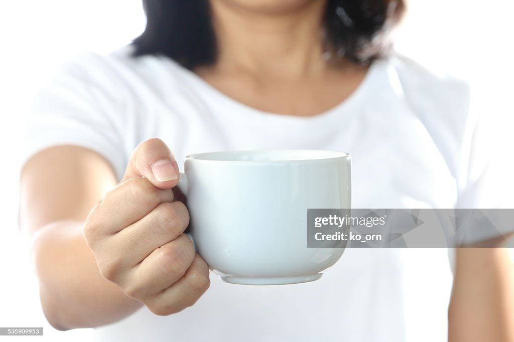 Woman holding a white coffee cup.