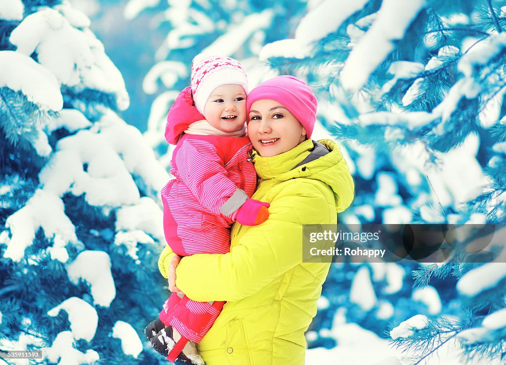 Mother and child having fun in winter snowy day