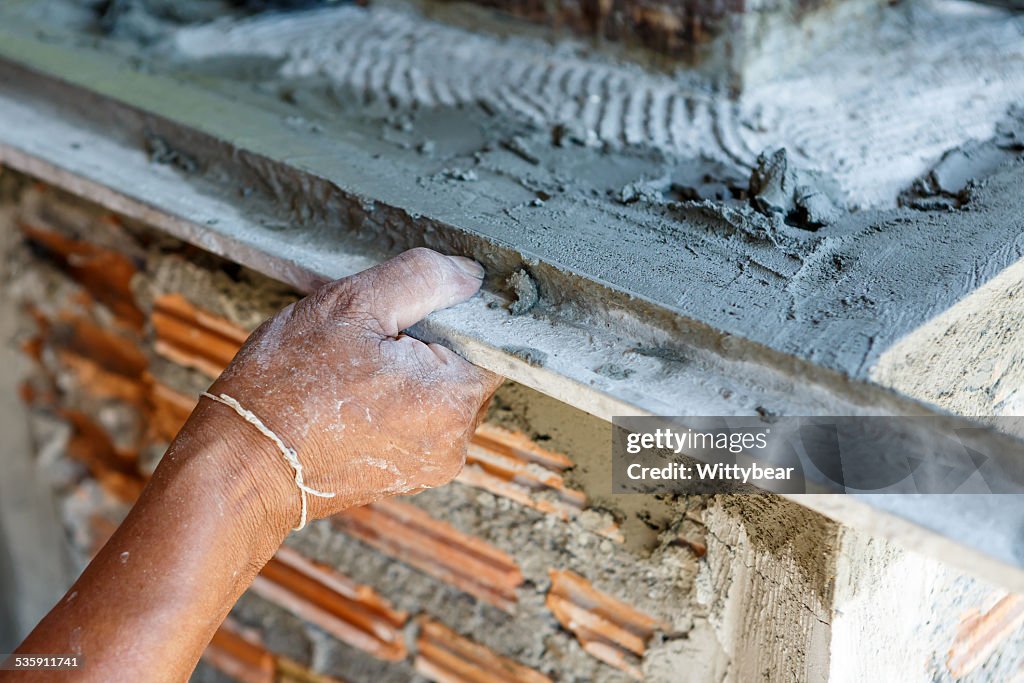 Plasterer en pared de hormigón Trabajador de construcción de la casa