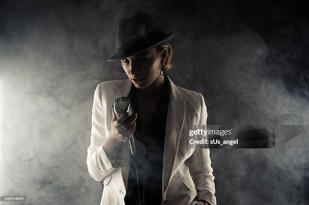 Fashion woman with retro microphone in smoke