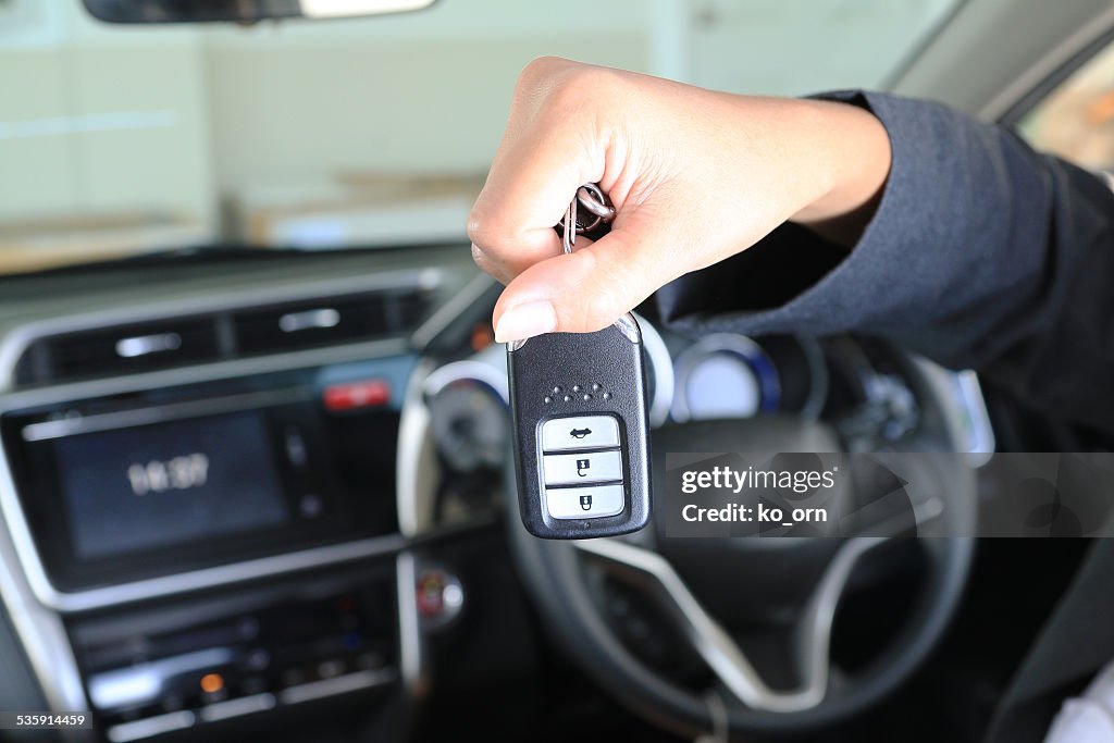 Business woman show remote key in modern vehicle car.