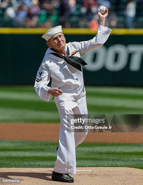 United States Navy 2nd Class Petty Officer Mr. Burke Waldron throws out the ceremonial first pitch prior to the game between the Seattle Mariners and...