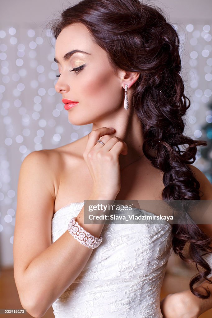 Beautiful elegant bride with dark hair posing at studio