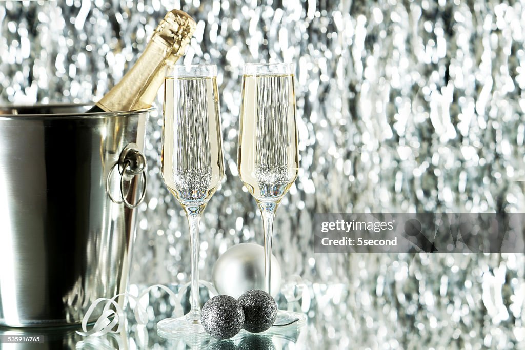 Bicchieri di champagne con una bottiglia in un secchio su sfondo