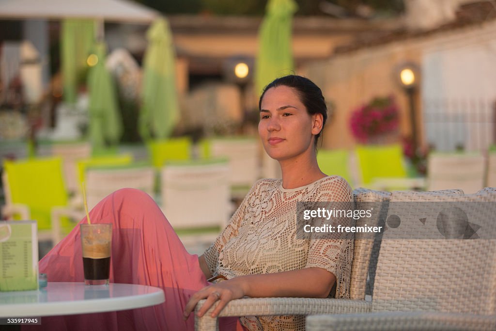 Woman is drinking juice and enjoy the beautiful seascape