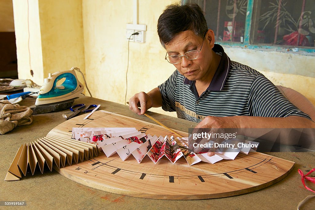 Man produces traditional Chinese fan in Yangshuo, China.