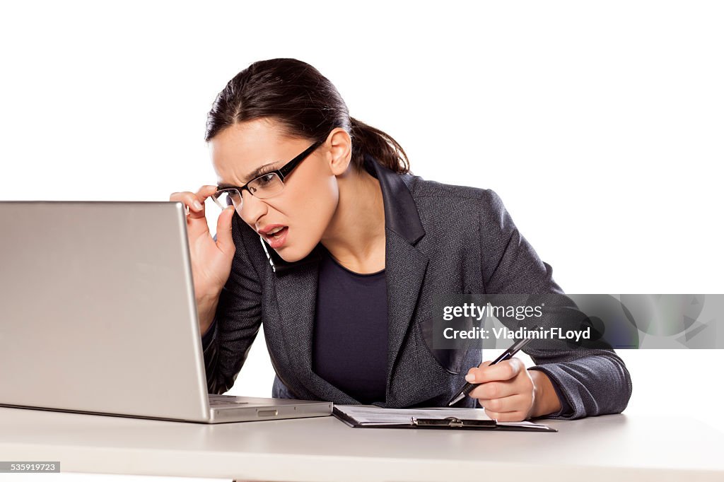Verwirrt business-Frau arbeitet auf einem laptop und Schreiben