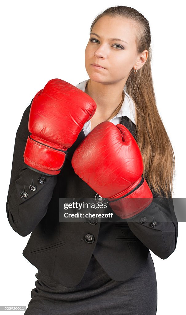 Businesswoman wearing boxing gloves, giving tough look at camera