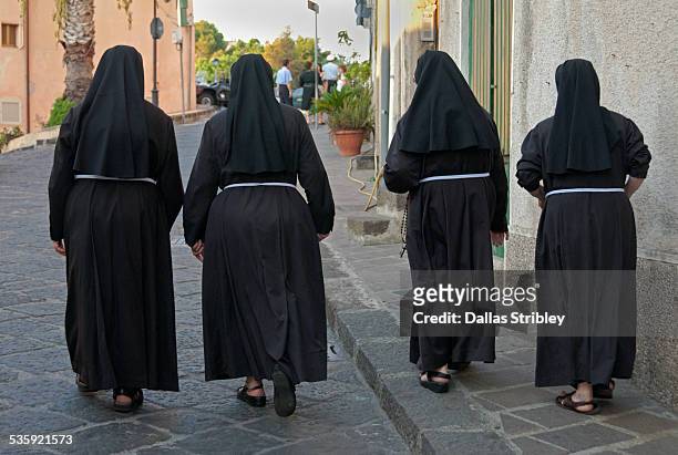 nuns walking to church, in lipari, sicily - monja fotografías e imágenes de stock
