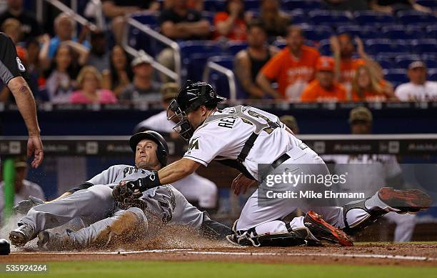David Freese of the Pittsburgh Pirates scores as J.T. Realmuto of the Miami Marlins applies the tag during a game at Marlins Park on May 30, 2016 in...