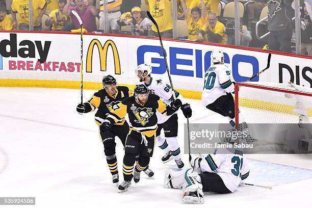 Bryan Rust of the Pittsburgh Penguins celebrates with Evgeni Malkin after scoring a first period goal against Martin Jones of the San Jose Sharks in...