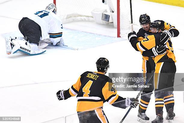 Bryan Rust of the Pittsburgh Penguins celebrates with Evgeni Malkin and Justin Schultz after scoring a first period goal against Martin Jones of the...