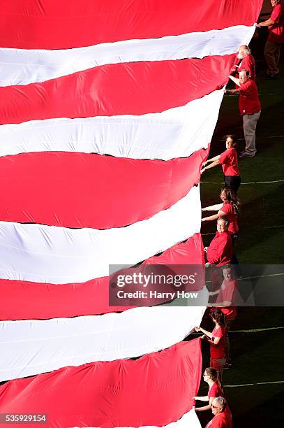 Volunteers hold up the American flag during the national anthem to celebrate Memorial Day before the game between the Detroit Tigers and the Los...