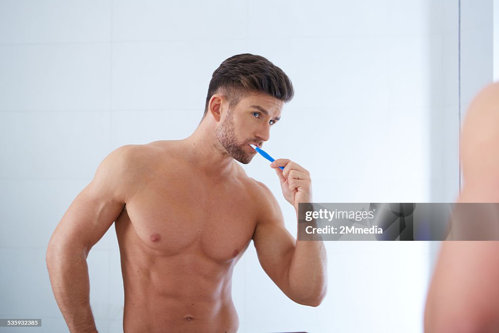 Young man brushing teeth