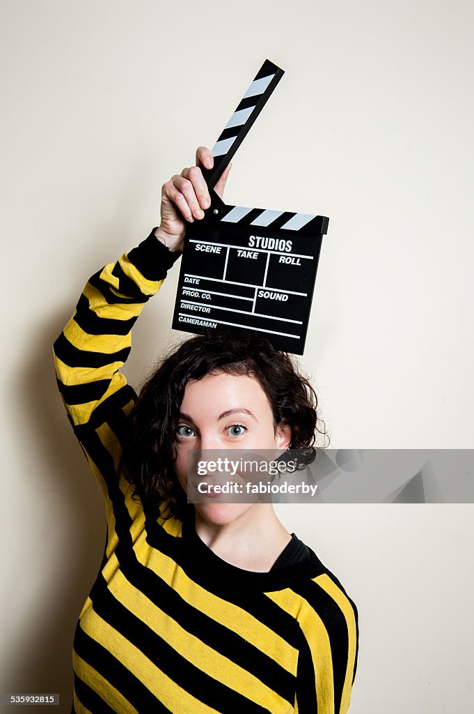 Smiling girl with movie clapper on white background