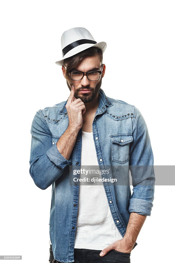 Bearded man with a hat posing in the studio