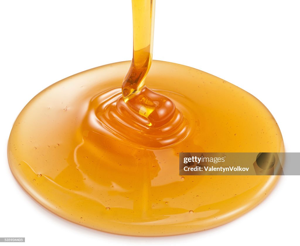 Honey flowing on white background.